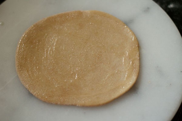applying oil on rolled paratha