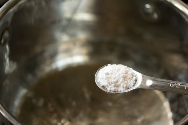 salt being added to the water in the pan. 