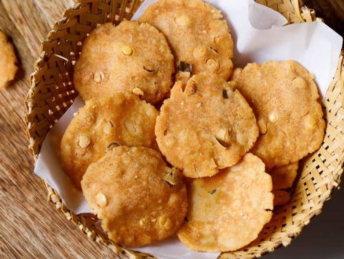 thattai placed on parchment paper in a cane basket.