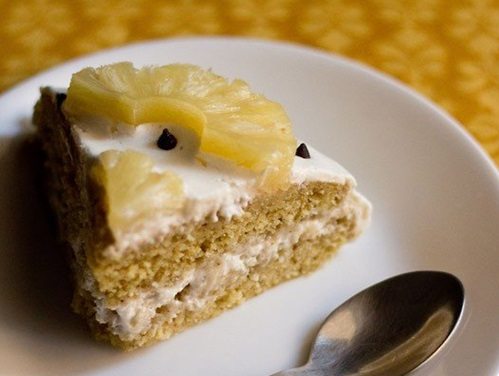 eggless pineapple cake slice on a white plate.