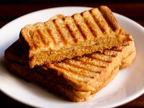 grilled cheese sandwich on white plate.