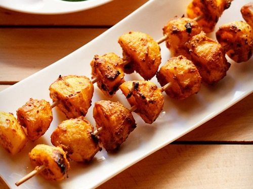 tandoori aloo tikka served on a white rectangular platter.