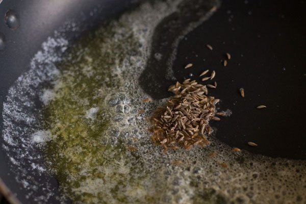 cumin seeds added to hot butter in the pan. 