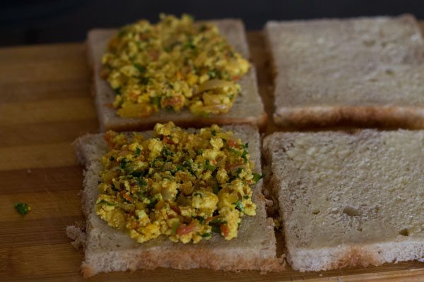 prepared paneer bhurji spread on buttered bread slices. 