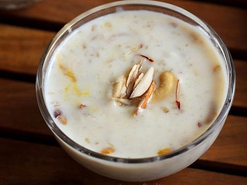 oats kheer garnished with chopped almonds in a glass bowl.