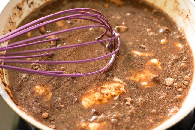 mixing ingredients in the pan with a whisk. 