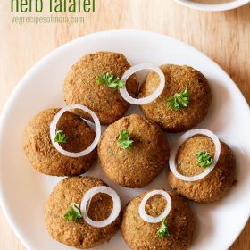 green falafel garnished with parsley and onion rings and served on a white platter with text layover.