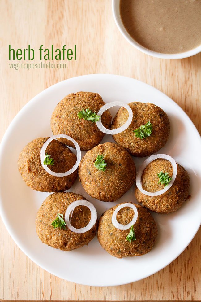 green falafel garnished with parsley and onion rings and served on a white platter with text layover.
