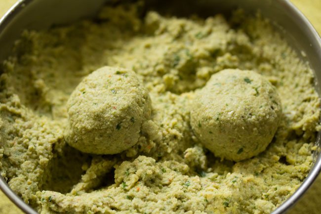 green falafel balls shaped from the prepared mixture. 