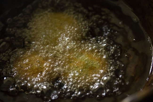 frying green falafel in hot oil till crisp and golden. 