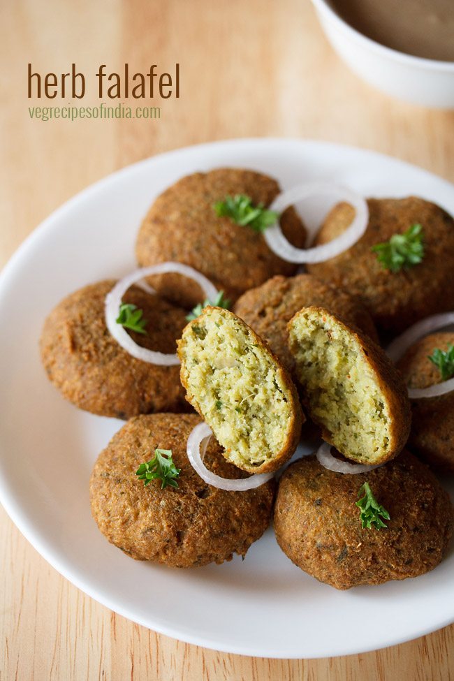 green falafel garnished with parsley and onion rings and served on a white platter with text layover. 