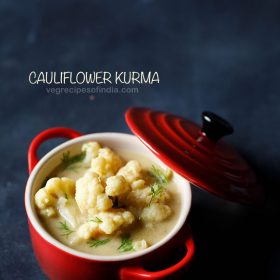 top shot of cauliflower kurma in a red bowl with a red lid slightly tilted at the side of bowl with a text layover