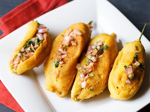 mirchi bajji on a white square plate.