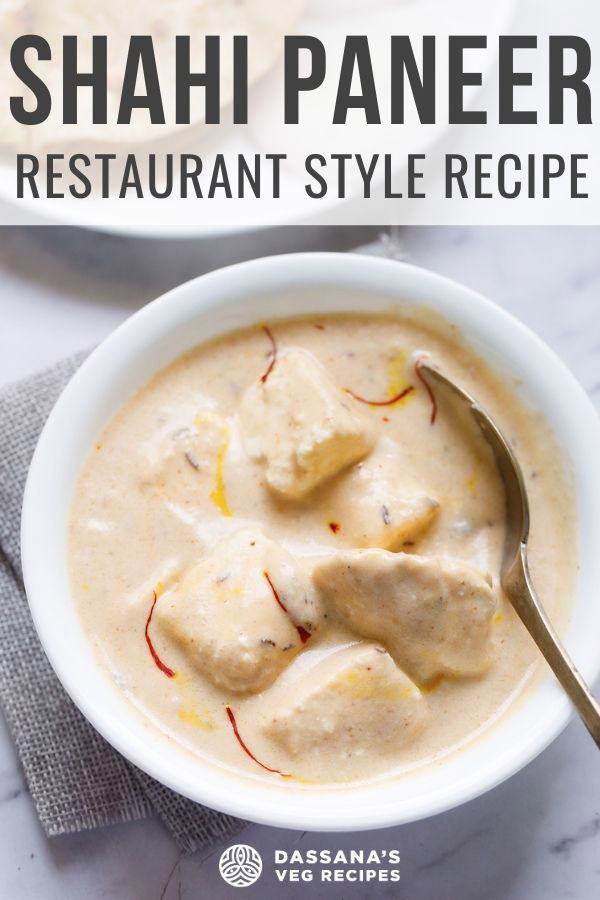 shahi paneer topped with some saffron strands served in a white bowl with a spoon inside the bowl on a white marble surface