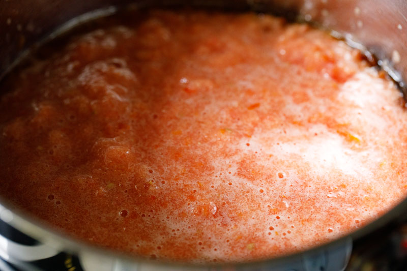 crushed tomatoes added to skillet with caramelized onions