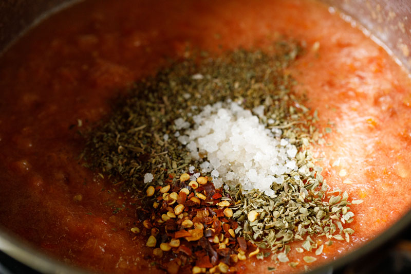 apices and salt added to pot with crushed tomatoes