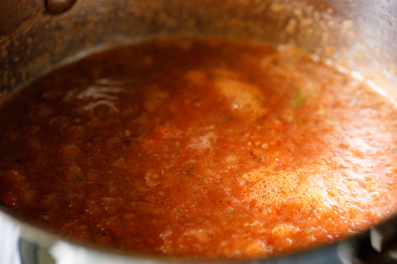 all ingredients for marinara sauce stirred together and simmering in the skillet