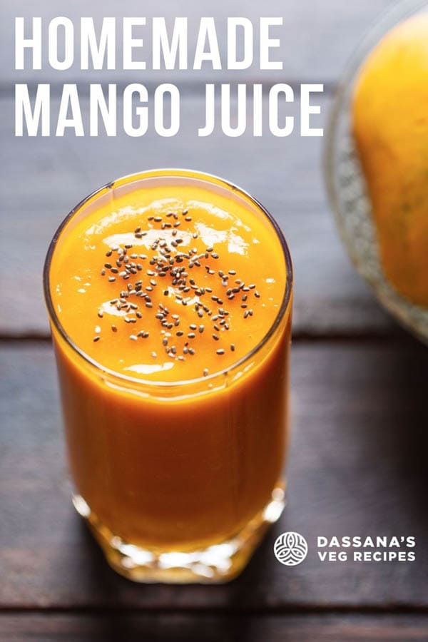 top shot shot of mango juice in a glass topped with chia seeds on a wooden table with a side of mangoes on a glass bowl with a text layover