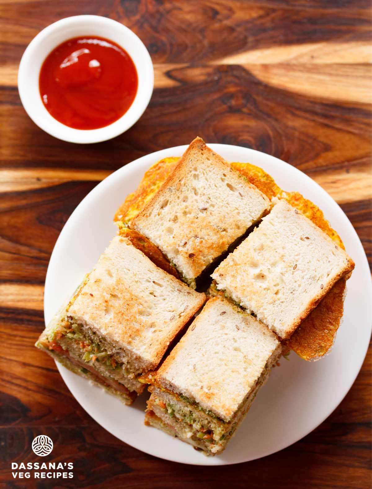 club sandwiches squares in a white plate with tomato ketchup.