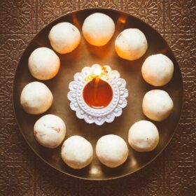 The rava laddu is formed in a circle with an earthen lamp lit on a bronze plate in the middle.