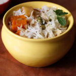 vegetable biryani in a yellow ceramic handi or pot.