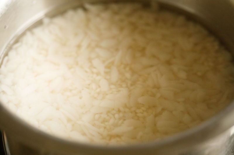 idli rice and thick flattened rice soaking in water.