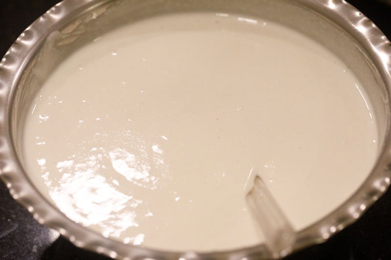 both lentil batter and rice batter in a mixing bowl with a spatula.