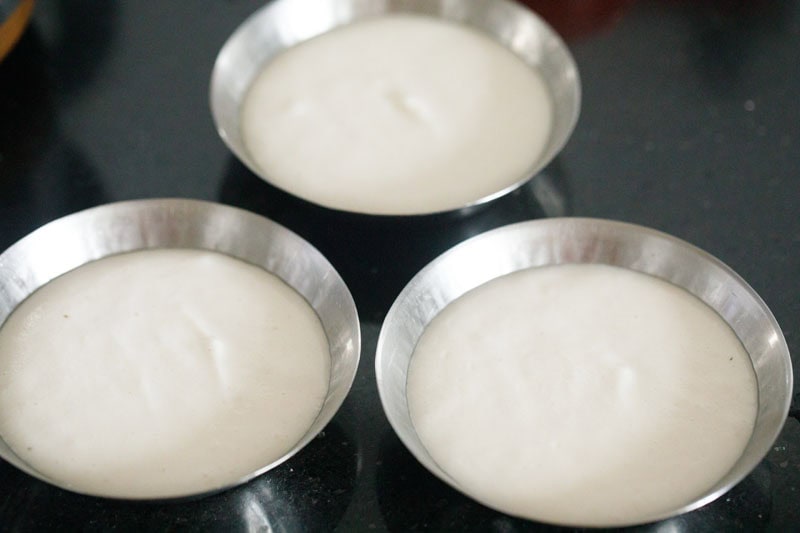 tatte idli batter inside three plates.