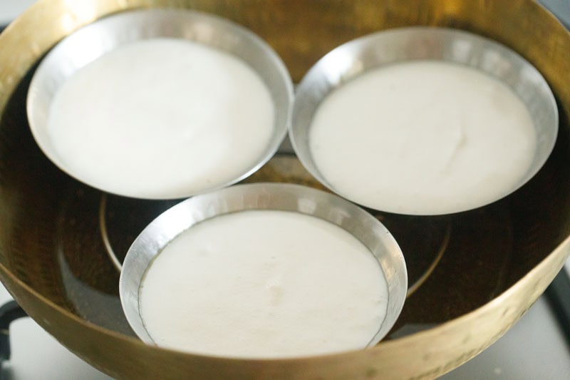 plate idli plates placed on trivet in a pan.