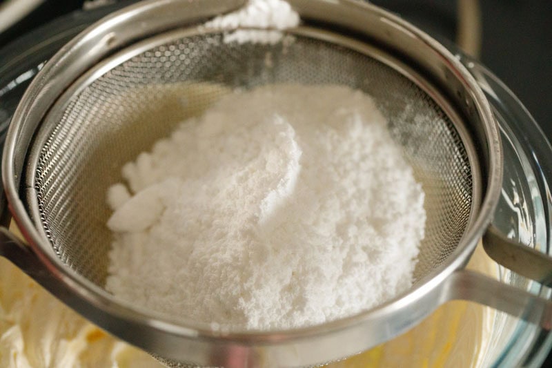 powdered sugar being sifted directly on the whipped butter.