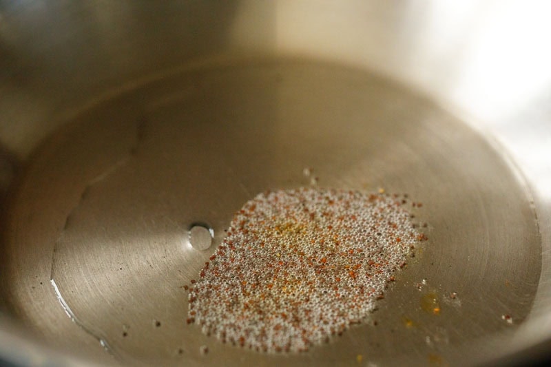 mustard seeds crackling in coconut oil in a pan.