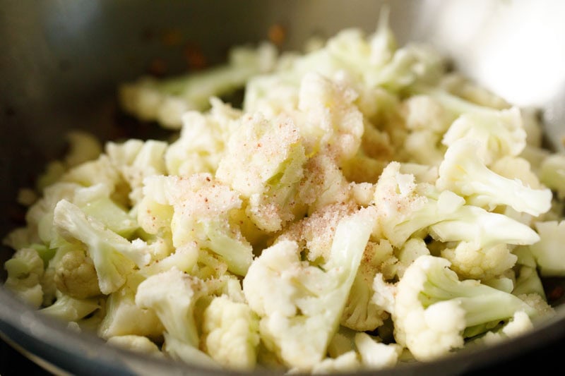 blanched cauliflower florets in pan with salt on top.