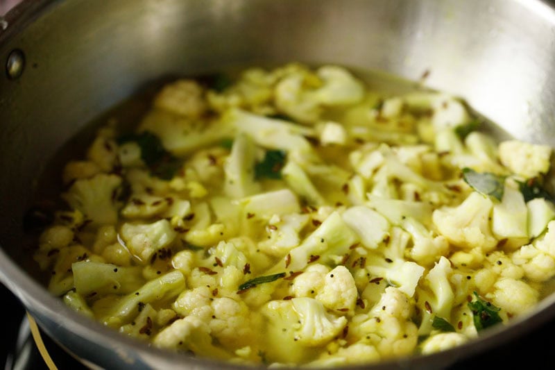 cauliflower florets mixed with water in pan.