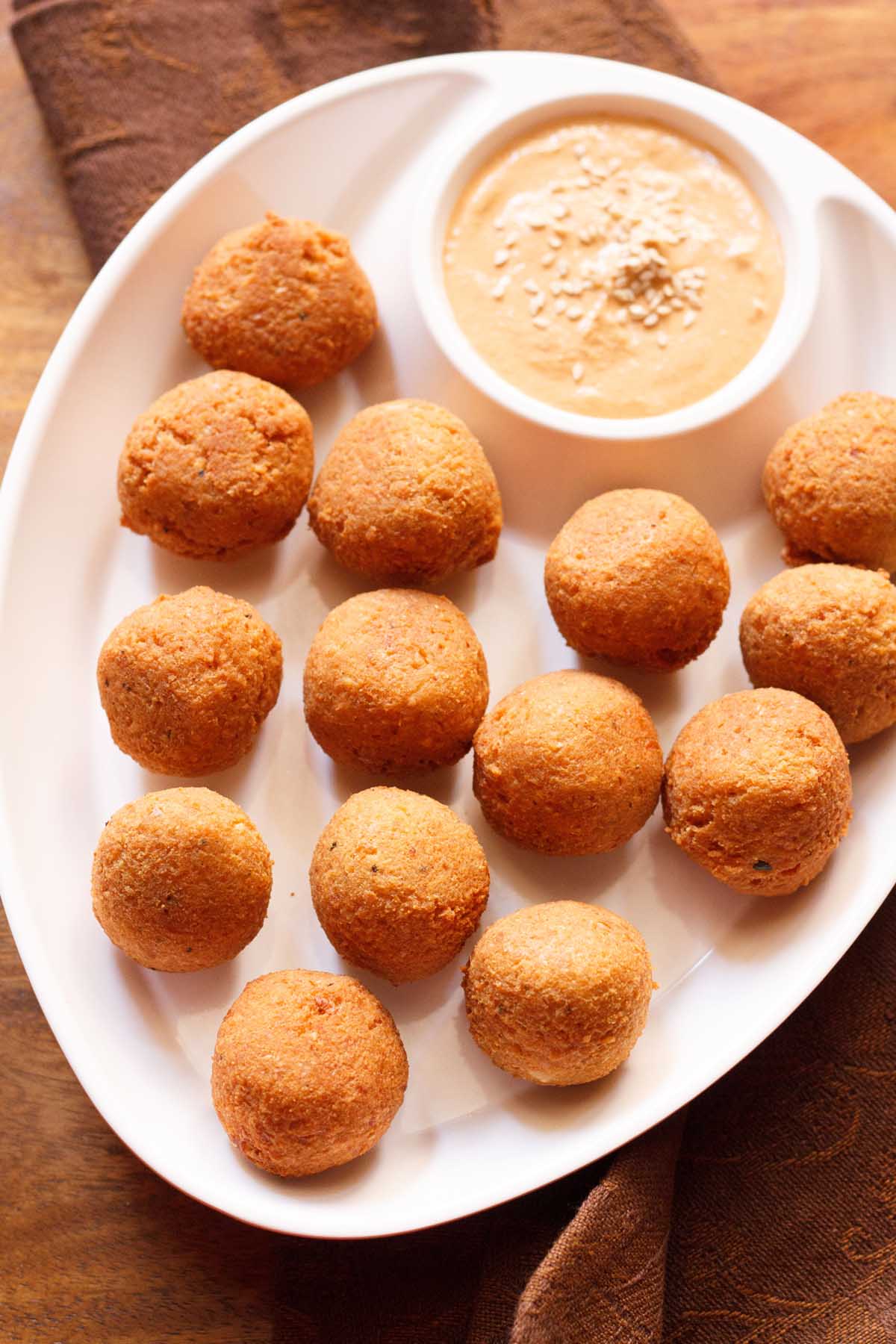 falafel served in a chip and dip platter with muhammara.