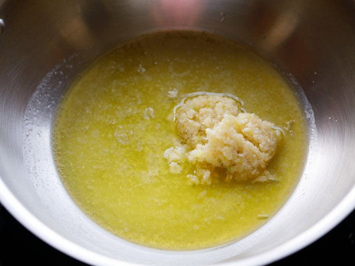 mound of minced garlic in melted butter in pan.