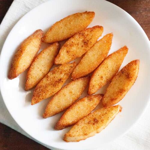 idli fry or fried idli on a white plate kept on a folded white napkin.