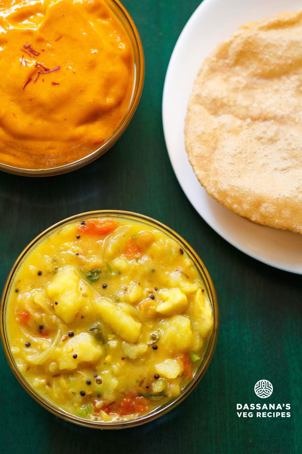 poori masala or poori curry combination on a green tray with a bow of aamras (thick mango pulp).