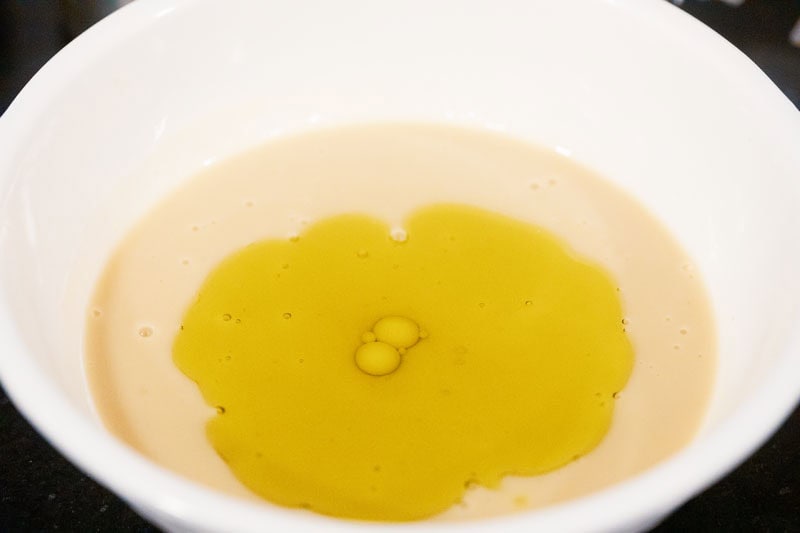 layer of avocado oil floating on top of liquid mixture in white bowl.