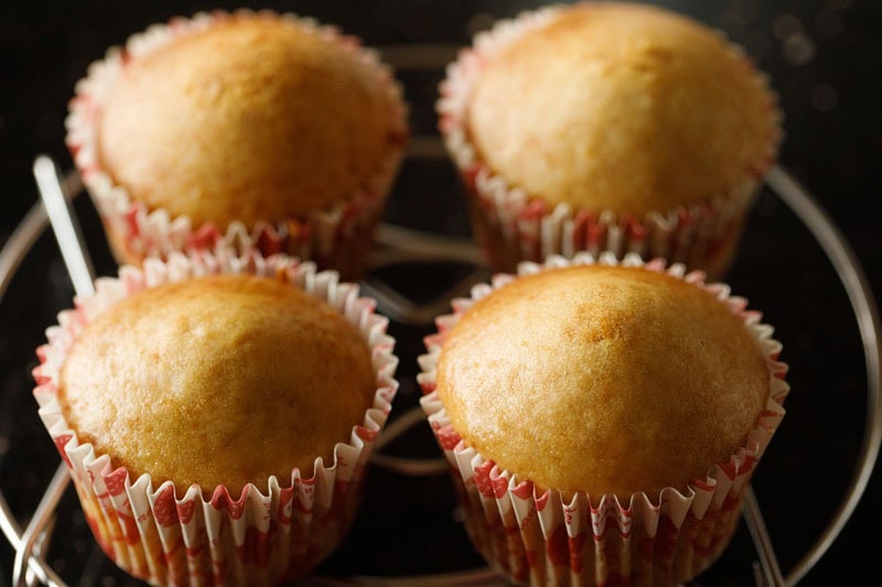 eggless vanilla cupcakes placed on wired rack.