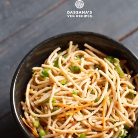 veg noodles or vegetable noodles served in a black bowl on a dark blue-gray wooden board