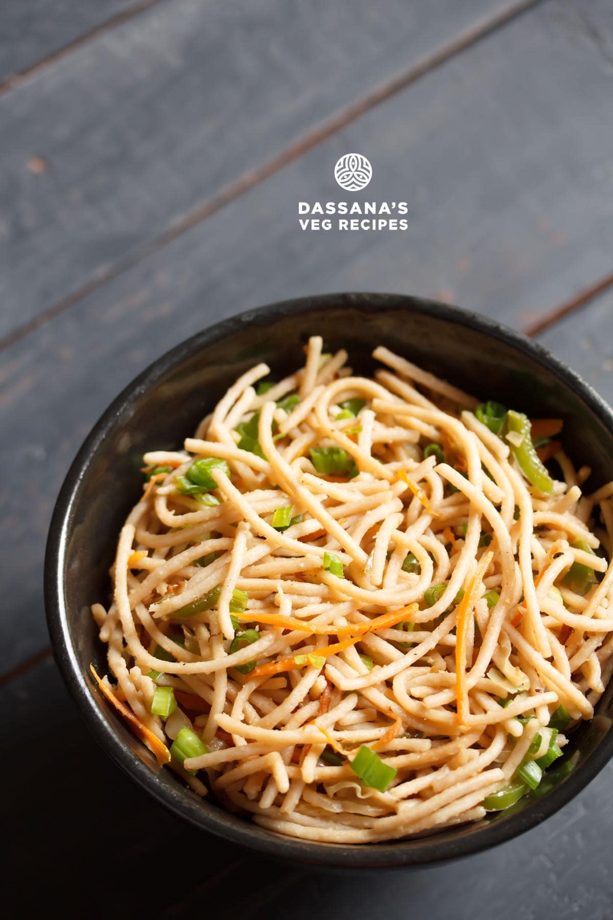 veg noodles or vegetable noodles served in a black bowl on a dark blue-gray wooden board