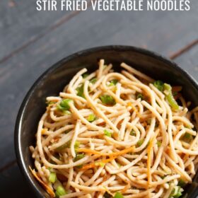 veg noodles served in a black bowl on a dark blue-gray wooden board with text layovers.