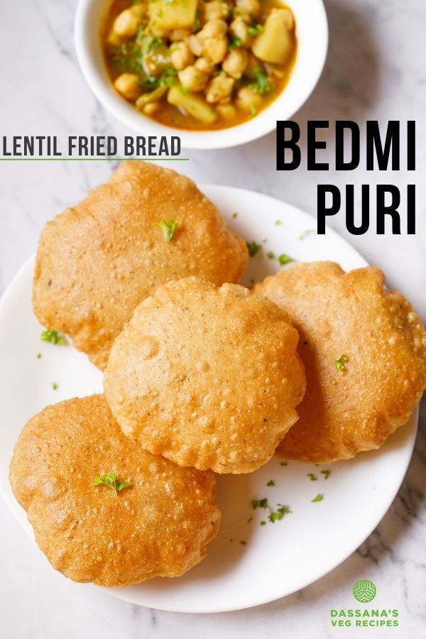 bedmi puri on white plate with chana aloo gravy (sabzi) placed on top in a white bowl.