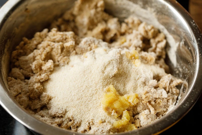 rava and ghee added to partly mixed dough ingredients to make bedmi puri recipe.