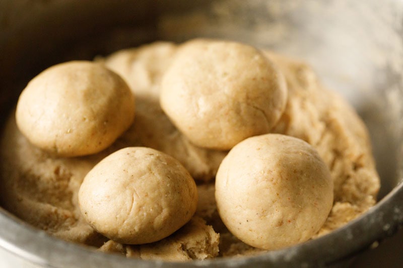 four neat round dough balls on top of the bedmi puri recipe dough.