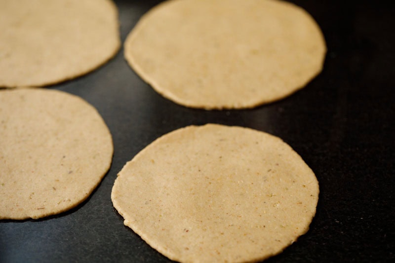 four rolled discs kept on granite countertop to make bedmi puri recipe. 