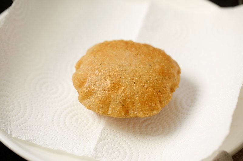 fried bedmi puri placed on kitchen paper towels.