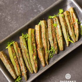 bharwa bhindi garnished with coriander leaves and served on a long platter.