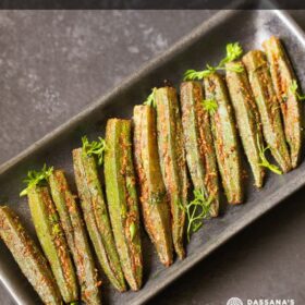 bharwa bhindi garnished with coriander leaves and served on a long platter with text layovers.