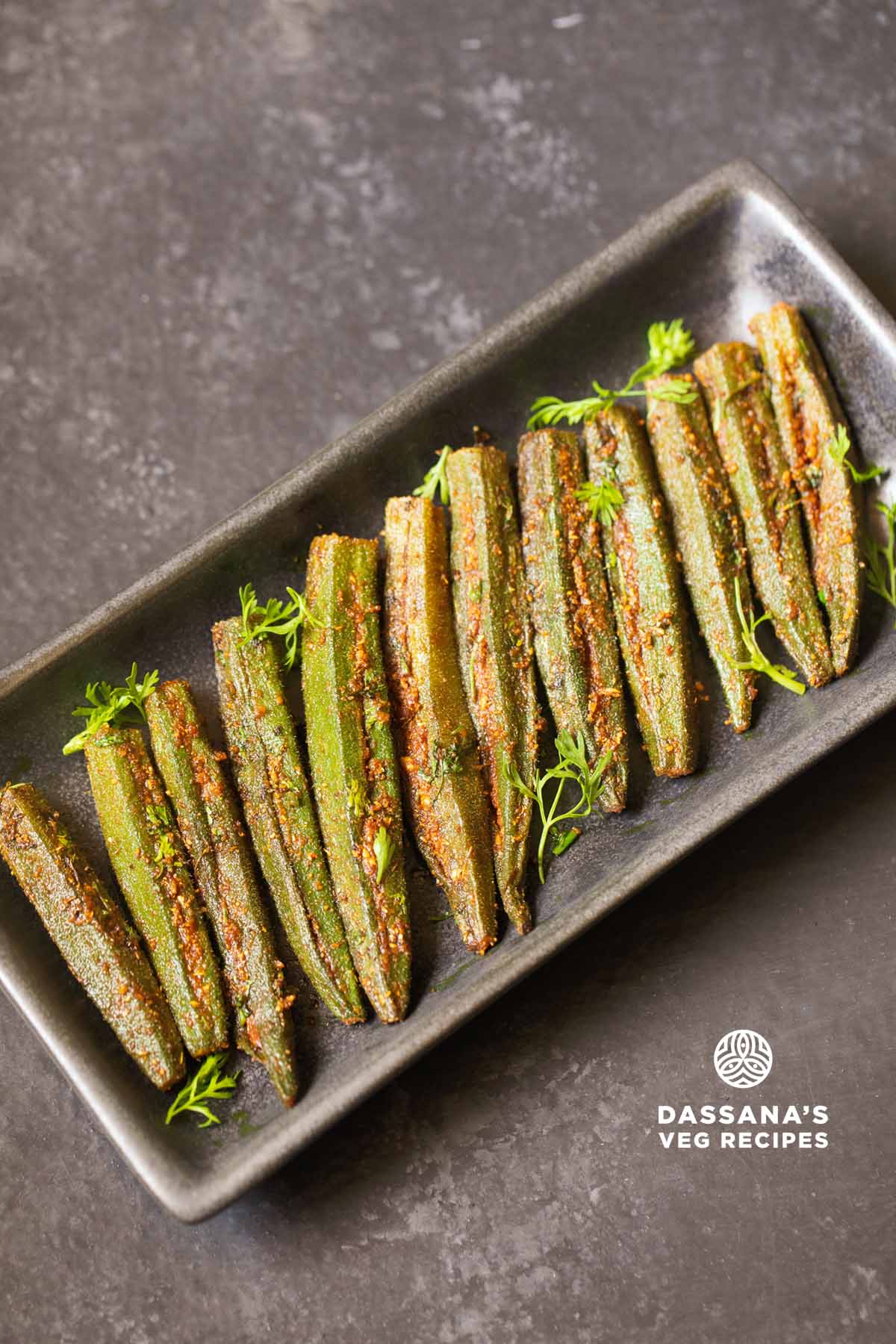 bharwa bhindi garnished with coriander leaves and served on a long platter.